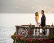 Ritratto di sposi con prosecco in una veranda sul lago di Como al tramonto