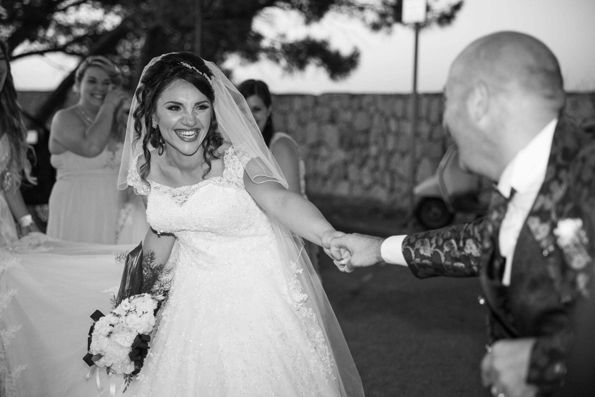 Sposi scherzano con gli amici. Reportage fotografico di matrimonio i Sicilia realizzato da Marco Terranova.