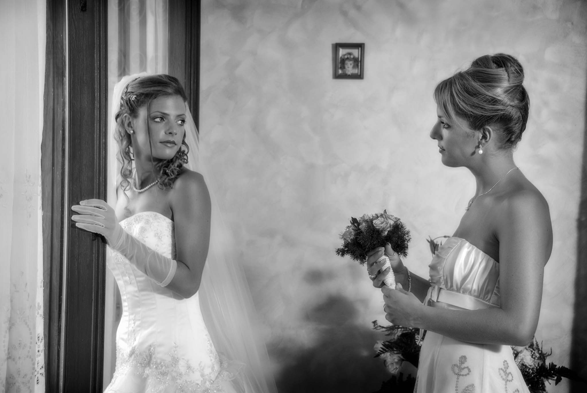 Ritratto della sposa con la sorella mentre le porge il bouquet. Fotografo di matrimonio in Sicilia, Marco Terranova.