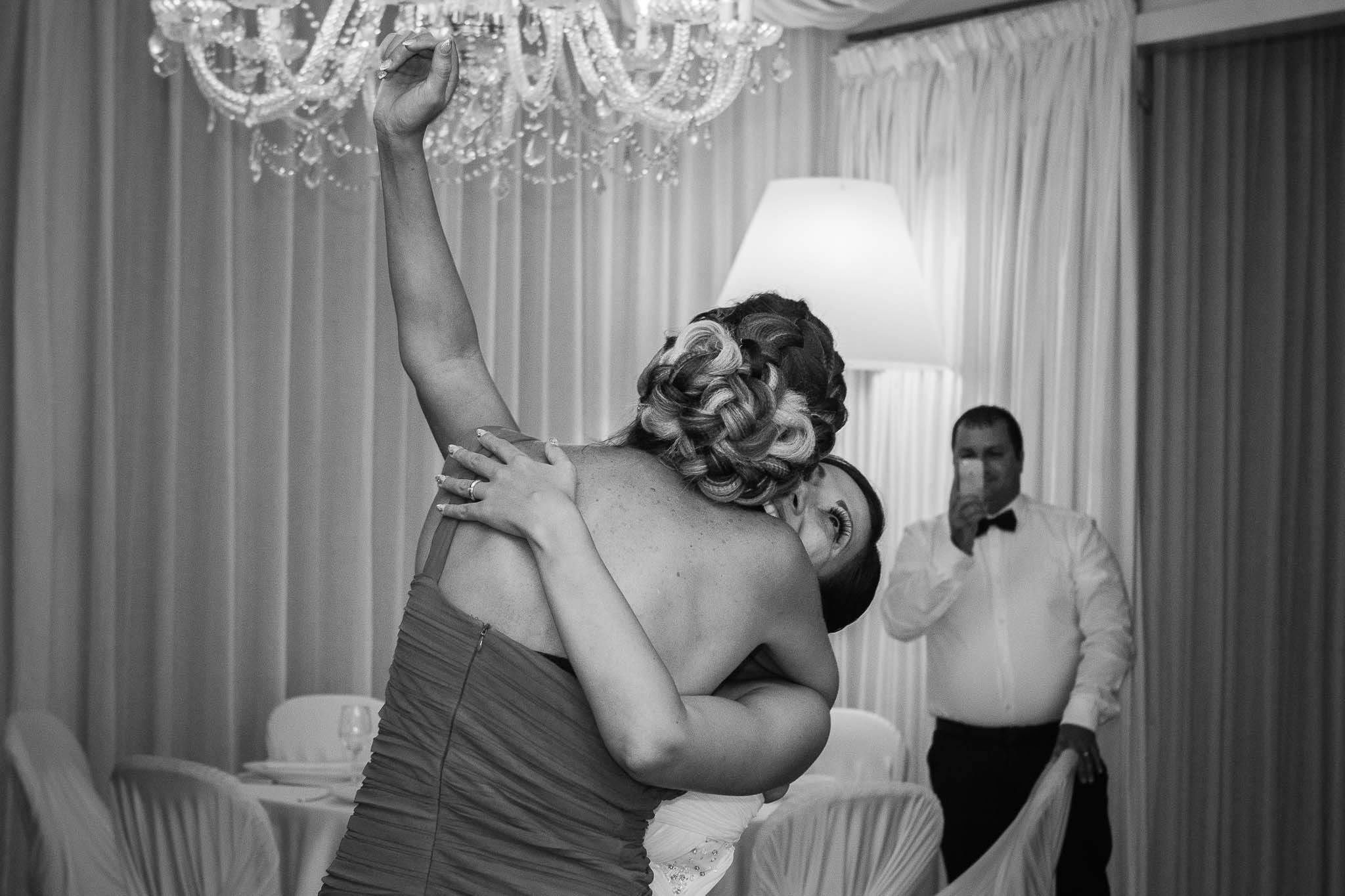 reportage-fotografico-nozze-cefalu-5143 La testimone abbraccia intensamente la sposa durante il ballo al ricevimento a Cefalù